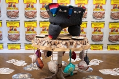 Invisible Woman Syndrome Installation, 2022-26, Mexican serape, Botonaduras, antique white felt, specialty fabric, gray felt, wool, bra insert cups, bras, oil sticks, Mexican pom-pom balls, thread & embroidery floss, 10 feet x 11.5 feet, installed at Martin Museum of Art, Waco, Texas, 2026